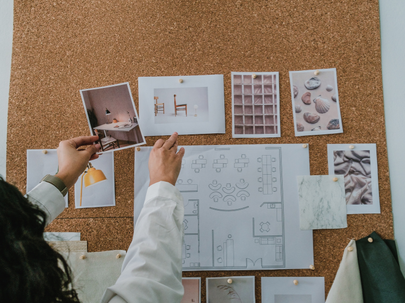 Designer sticks photos on a board