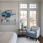 Bedroom vignette with chair, artwork, side table and lamp