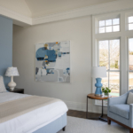 Bedroom vignette with chair, artwork, side table and lamp
