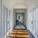 Dramatic hallway with french doors, bright light, runner.