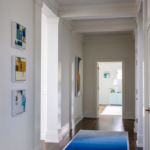 Hallway with artwork and colorful runner