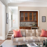Sofa and modern glass coffee table, with a bar/server in background.