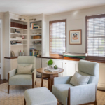 Sitting room with chairs, built in shelves, modern rug