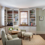 Sitting room with chairs, built in shelves, modern rug, hassock